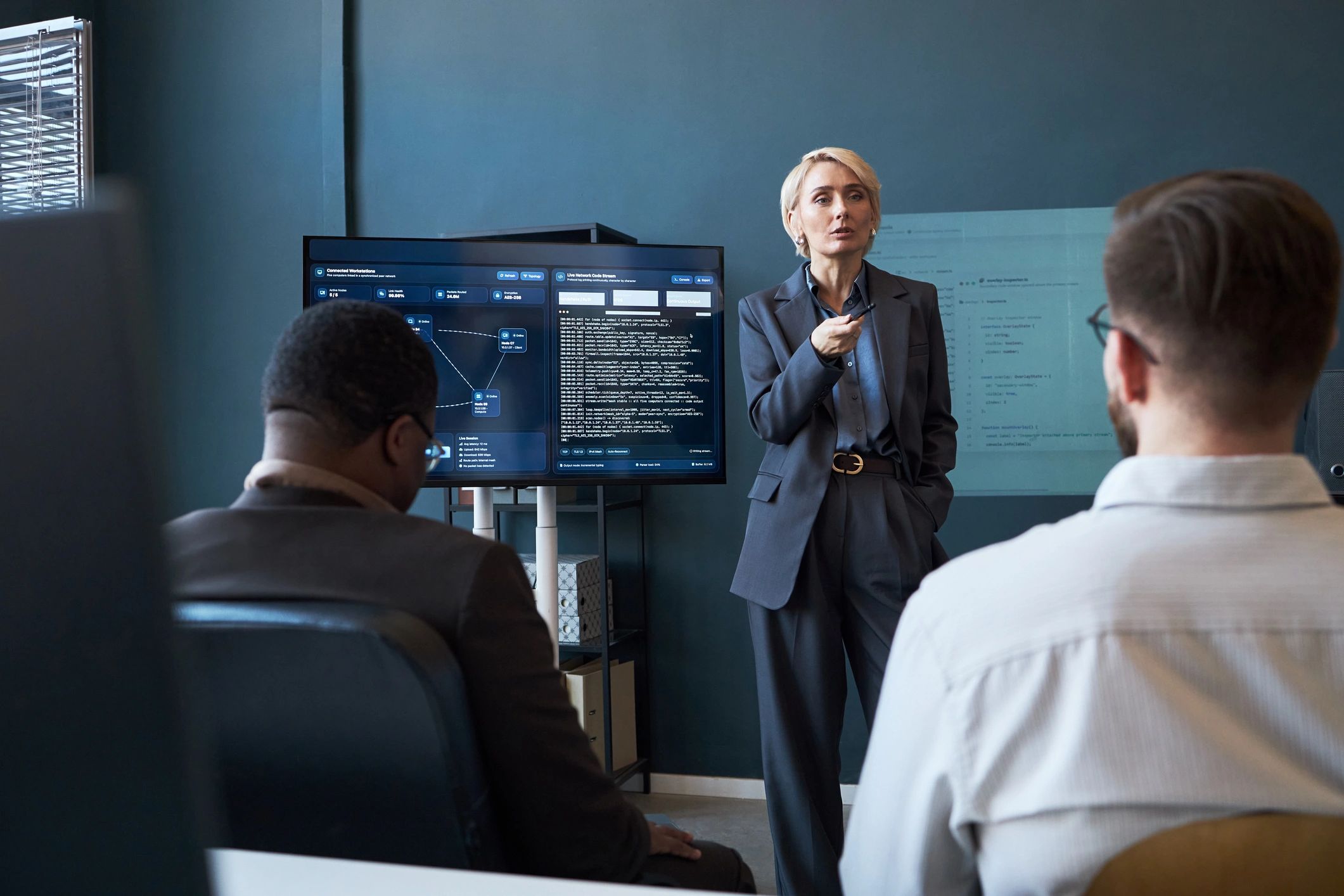 Businesswoman presenting software dashboard to colleagues during office meeting